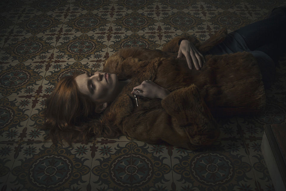Eine Frau liegt in einem Pelzmantel auf dem Boden