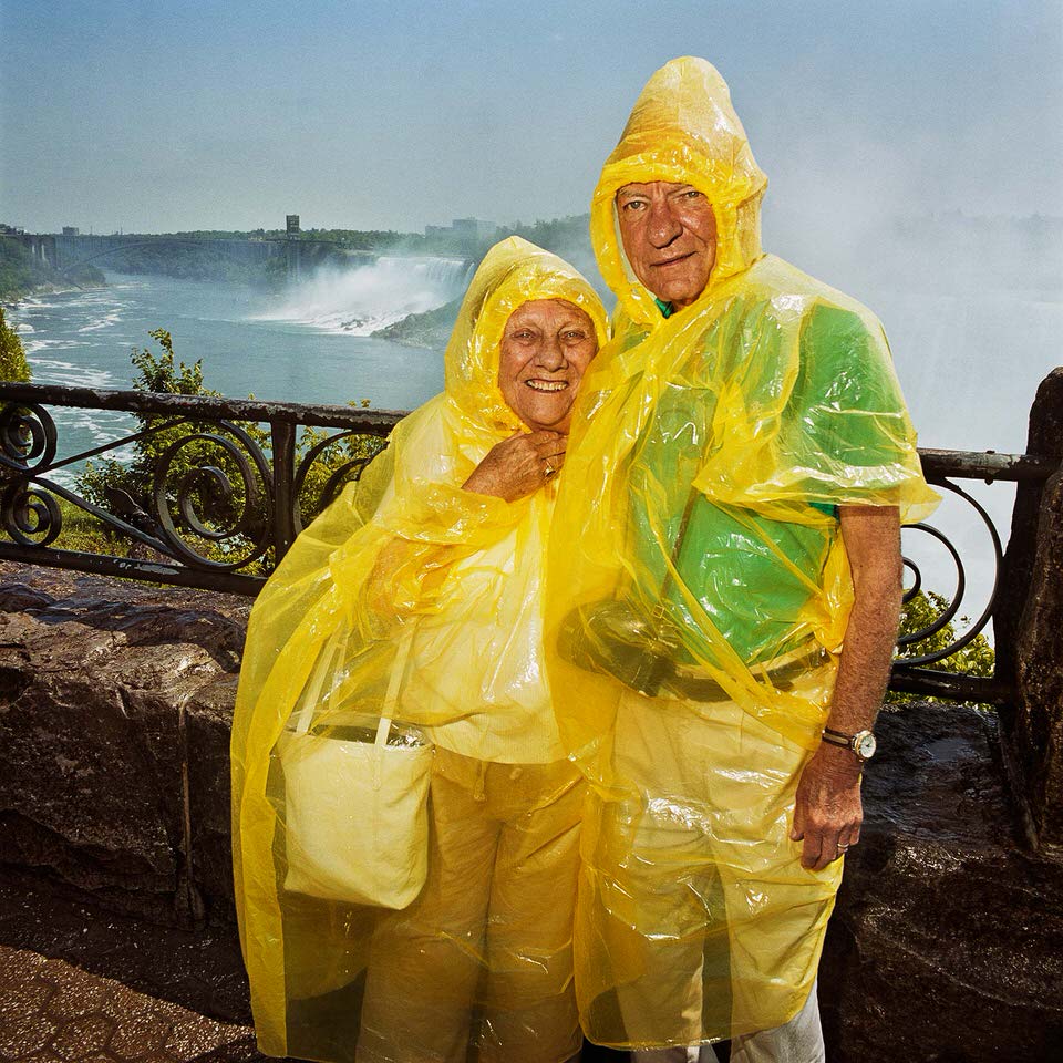Pärchen unter Regenjacken an den Niagara-Fällen. 