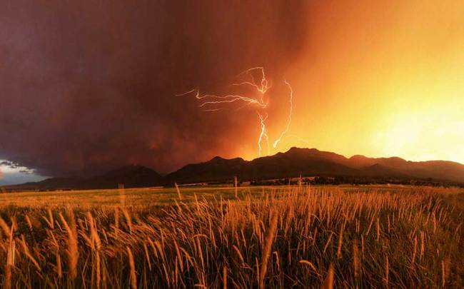 Blitze über einem Berg und einem Kornfeld