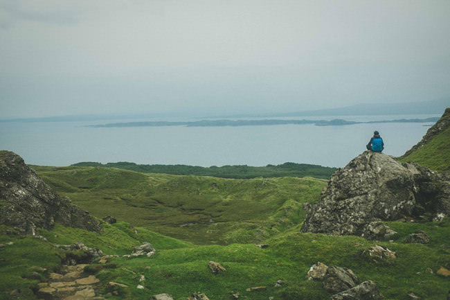 Eine Person sitzt in den schottischen Highlands