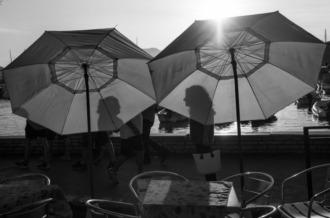 Zwei Frauen werfen Schatten auf zwei Schirme.