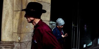 Straßenfotografie: Ein Mann mit Hut läuft vorbei.