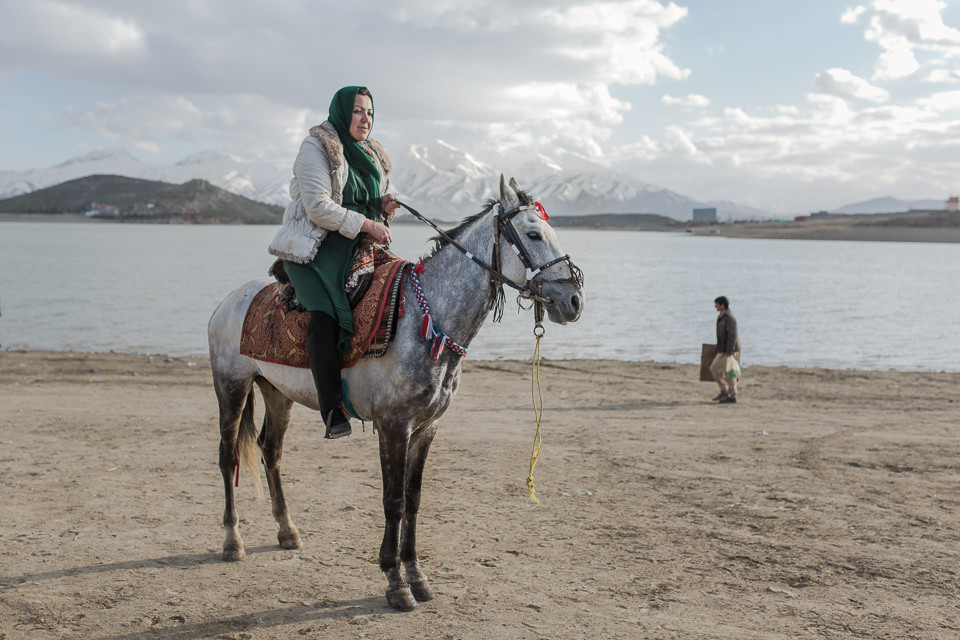 Eine Frau auf einem Pferd am Strand.