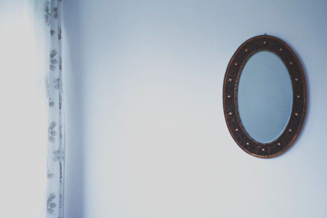 Ein runder Spiegel an einer Wand.