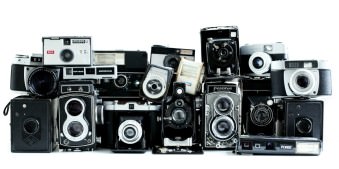Viele alte Fotoapparate, aufgereiht und aufgetürmt.