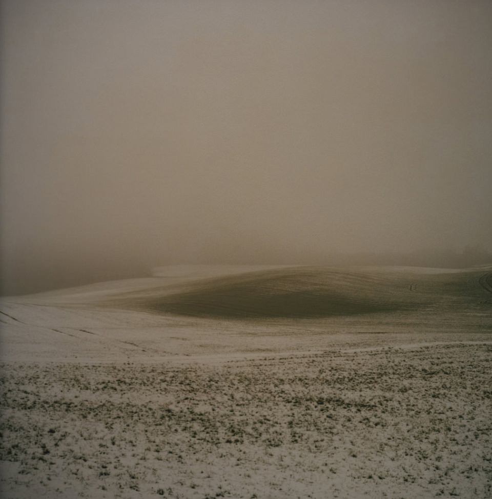 Ein schneebedecktes Feld im Nebel.