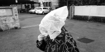 Eine Frau hat eine weiße Plastiktüte auf dem Kopf.