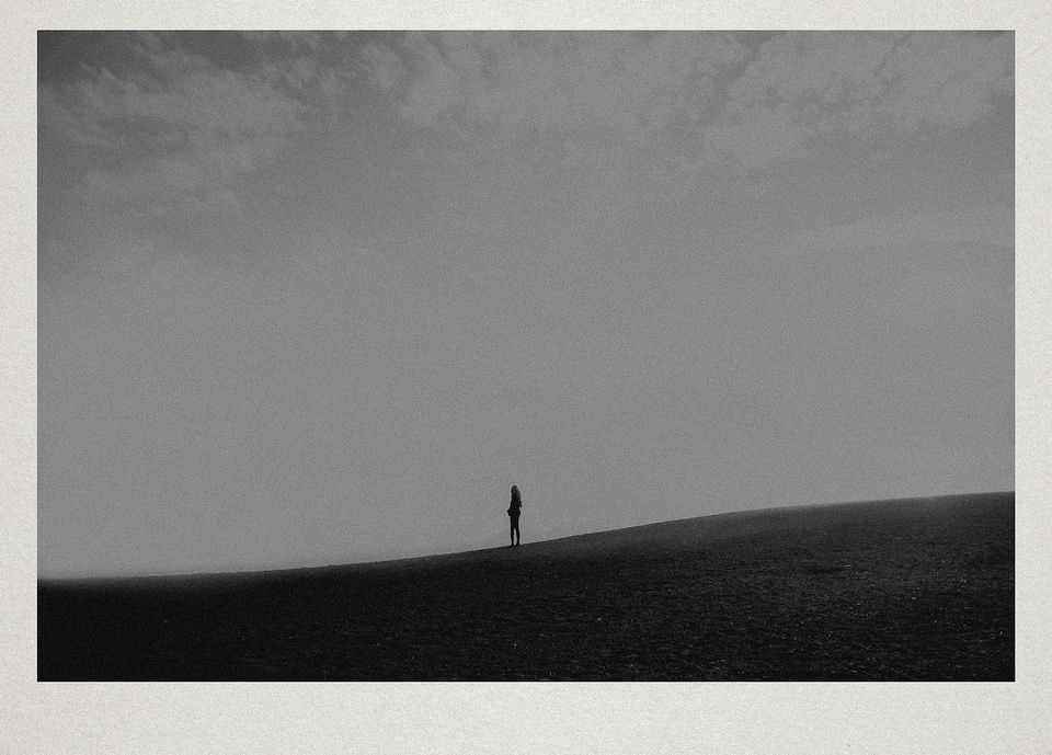 Eine Person steht auf einem Hügel.
