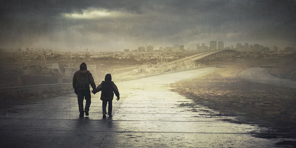Zwei Menschen laufen eine Straße entlang, die auf eine zerstörte Stadt zuführt.