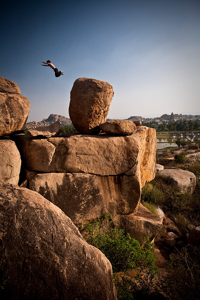 Ein Mann springt von einem Felsen.