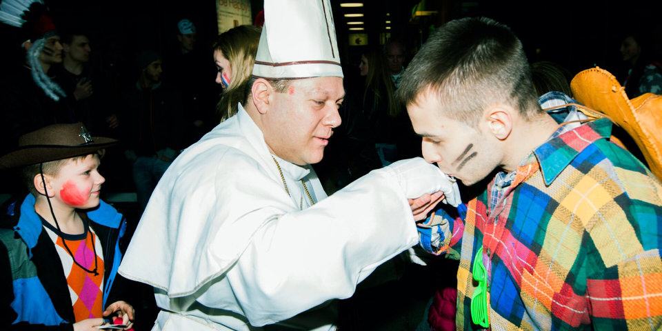 Karneval: Ein Cowboy küsst einem Papst die Hand.