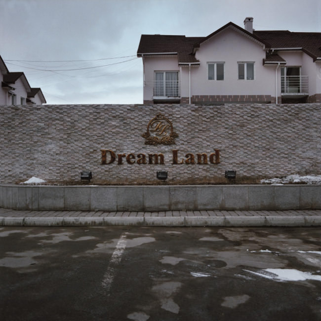 Ein Parkplatz vor einer Mauer mit der Aufschrift Dream Land.