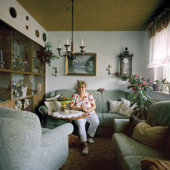 Eine ältere Frau sitzt in ihrem Wohnzimmer