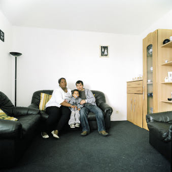 Eine junge Familie auf dem Sofa in ihrem Wohnzimmer