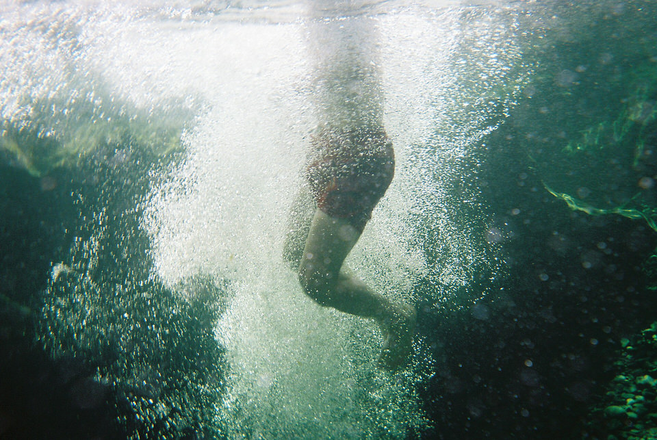 Eine Unterwasseraufnahme von gerade eingetauchten Beinen. 