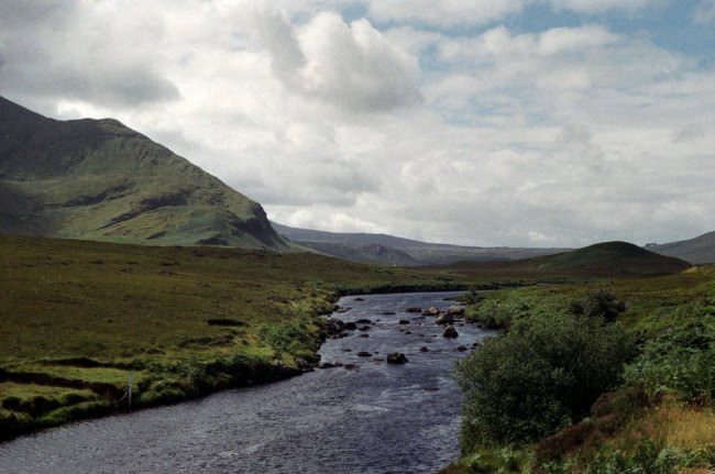 Ein Fluss in der grünen Landschaft Schottlands.