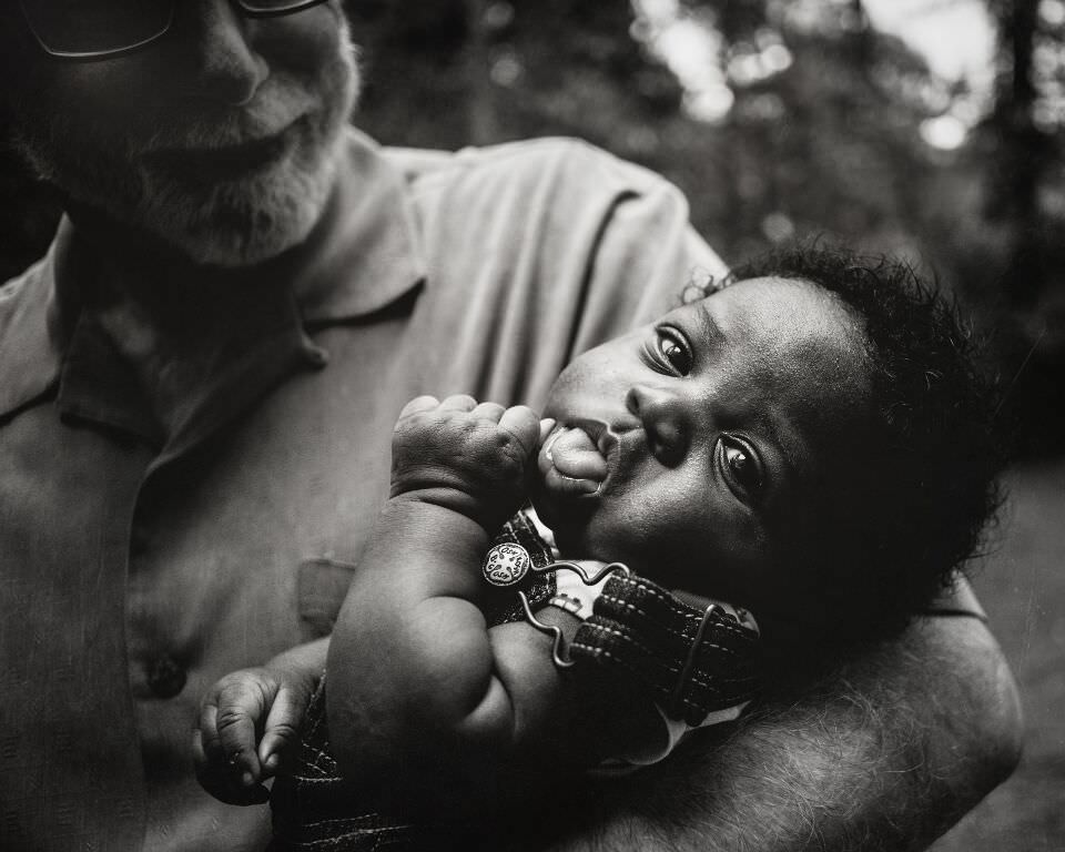 Ein Baby auf dem Arm seiner Großvaters.