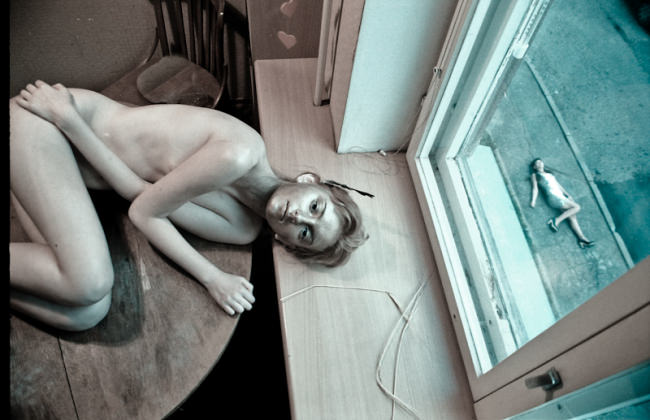 Nackte Sirene liegt am Fenster, zweite Frau draußen auf dem Boden