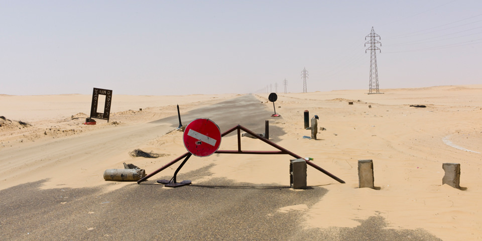 Absperrrung auf einer Straße durch die Wüste.