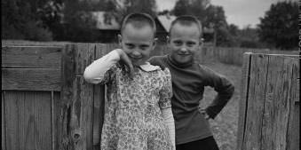 Zwei Kinder an einem Zaun