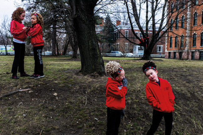 Kinder in roten Jacken in einem Park.