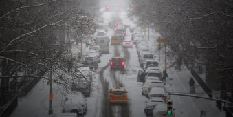 Autoverkehr auf einer verschneiten Straße in New York.