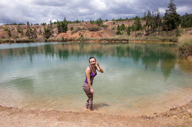 Eine lachende Frau an einem See.