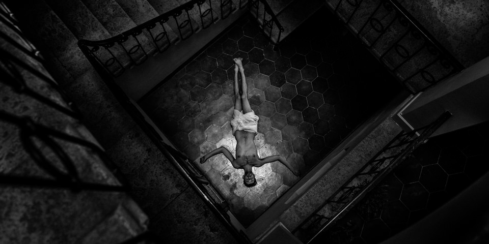 Ein Mann liegt am Boden eines Treppenhauses