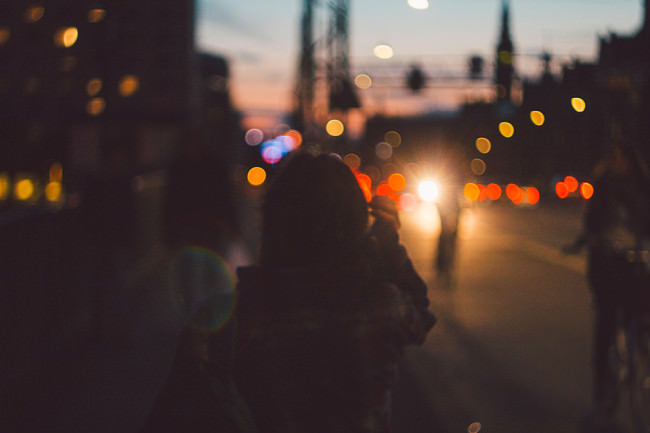 Silhouette einer Person in einem Bokehmeer aus Stadtlichtern.