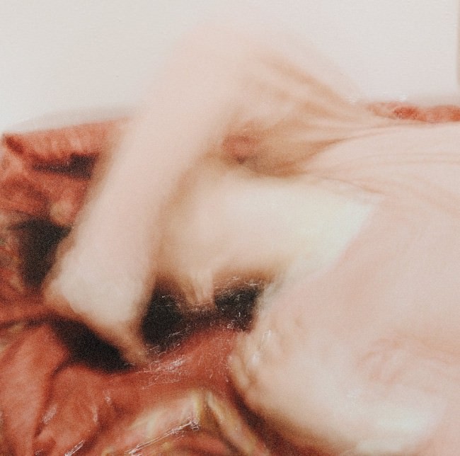 Eine verschwommene Frau bedeckt mit dem Arm ihr Gesicht