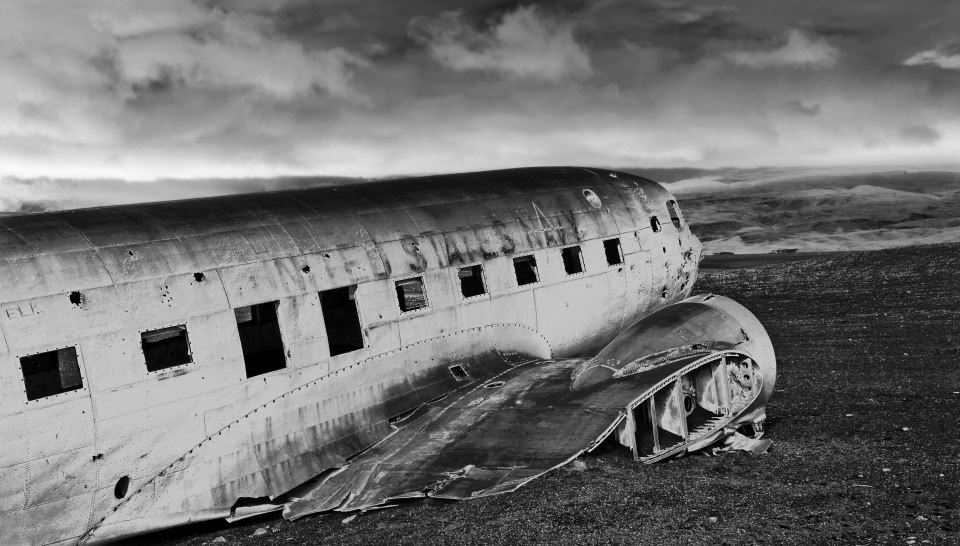 Flugzeugwrack in einer Landschaft in schwarzweiß.
