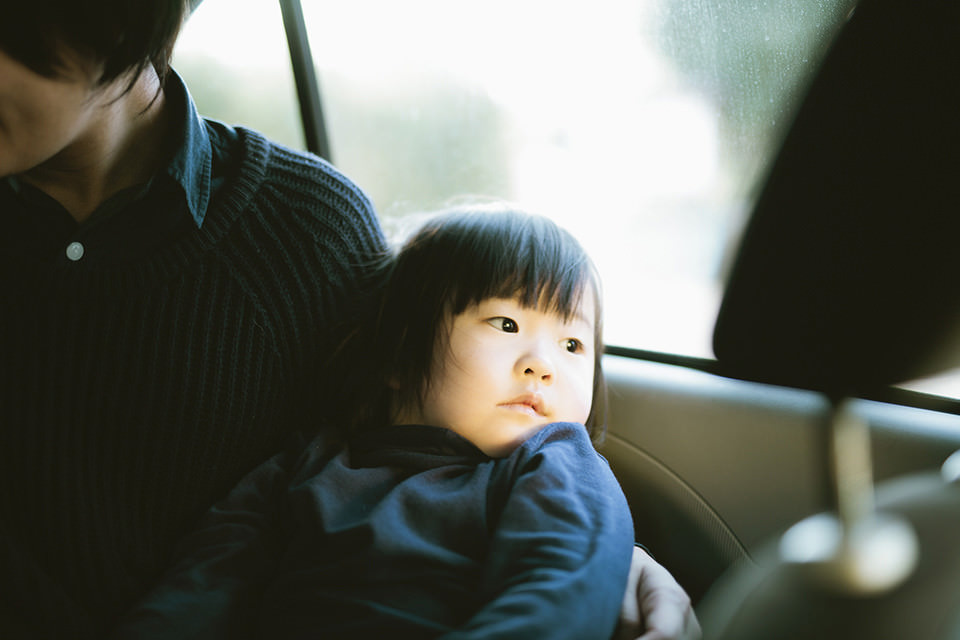 Ein Kind sitzt auf dem Schoß eines Erwachsenen im Auto