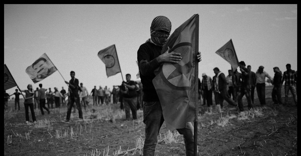 Ein kurdischer Demonstrant hält eine PKK-Flagge.