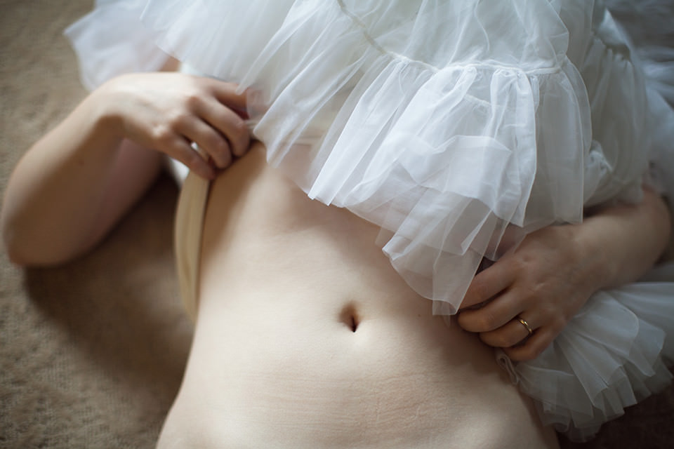 Ein weiblicher Bauch, die Brust ist von einem Tütü bedeckt.