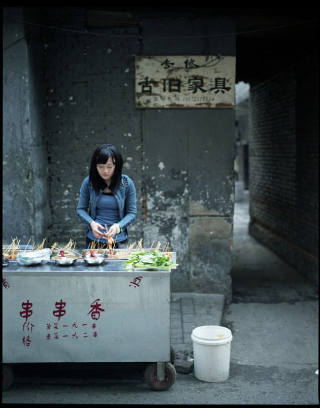 Eine junge Frau verkauft Essen an einem Straßenimbiss