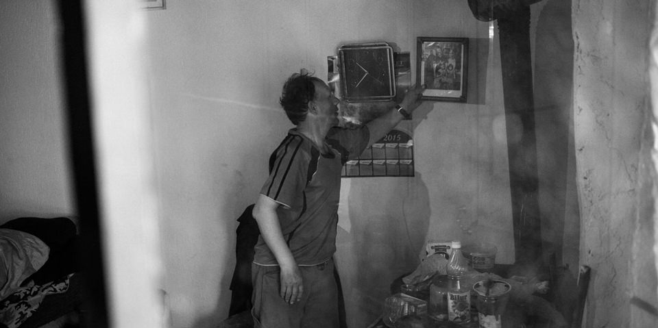 Ein Mann zeigt auf ein Foto, das an der Wand hängt.