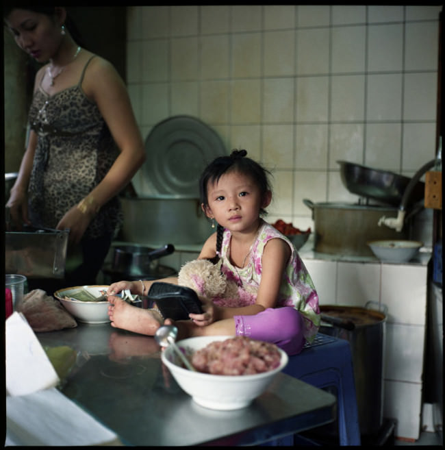 Ein kleines Mädchen sitzt in einer Küche