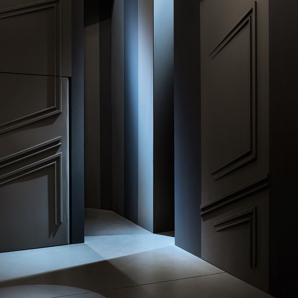 Schwarz-blaues Licht- und Schattenspiel zwischen den Wänden einer Kulisse.