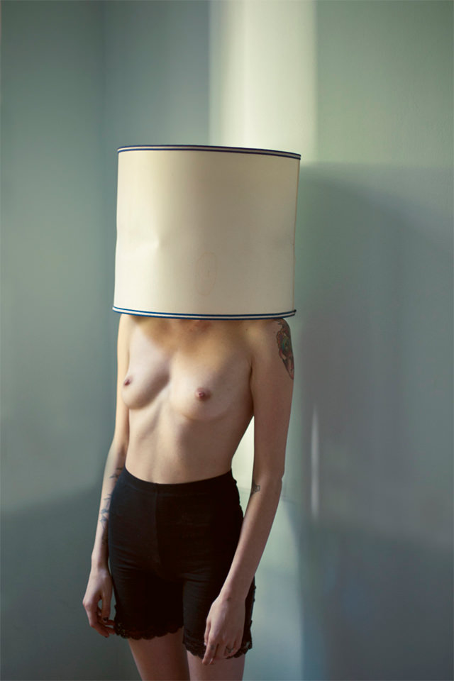 Eine Frau mit Lampenschirm auf dem Kopf
