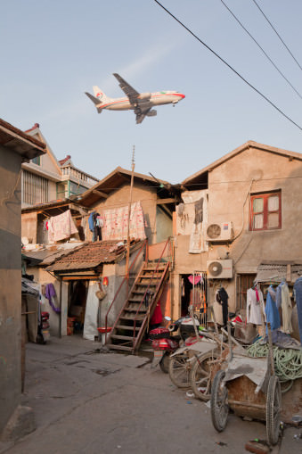 tieffliegendes Flugzeug über einem kleinteiligen Wohngebiet