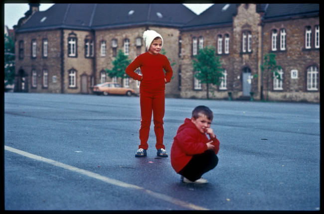 Kinder in roten Sachen stehen auf der Straße.