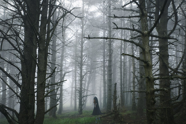 Eine Frau mit Kutte im Wald