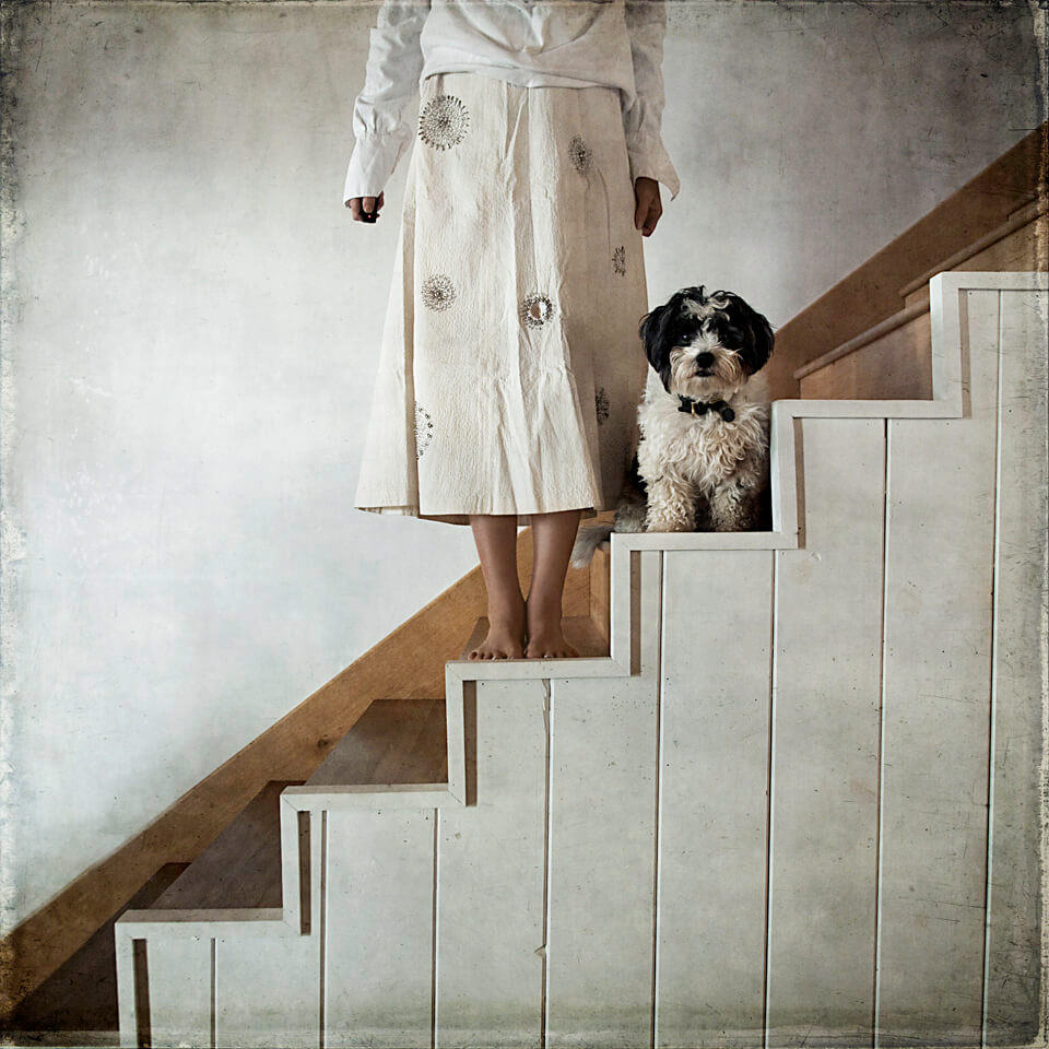 Eine Frau und ein Hund stehen auf einer weißen Treppe.