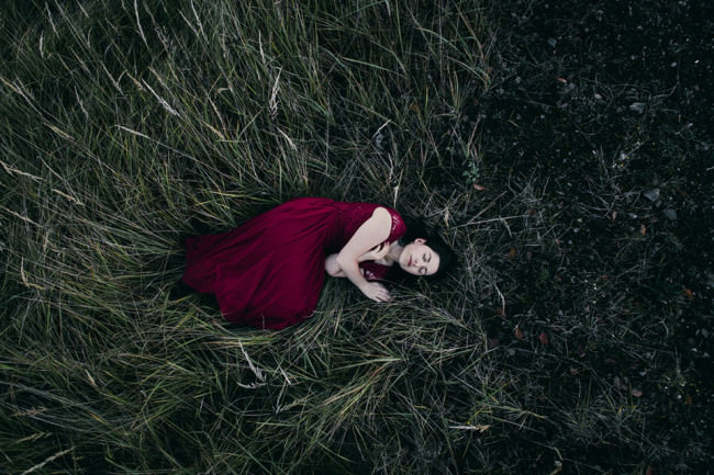 Eine Frau liegt im Gras