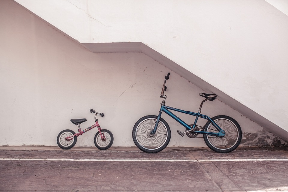 Zwei Fahrräder unter einer Betontreppe.