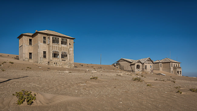 Verfallene Häuser in einer Wüste.