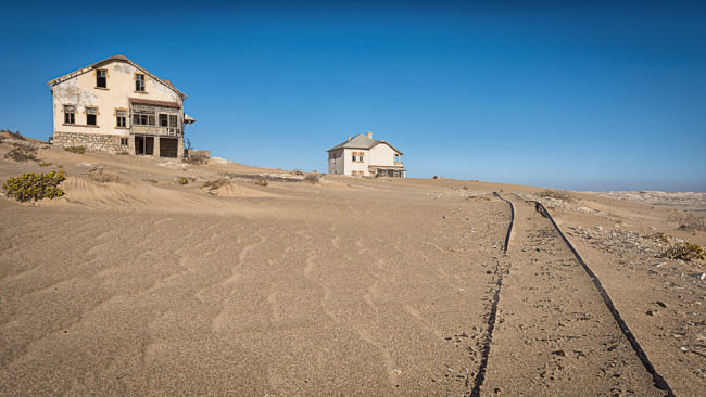 Verfallene Häuser in einer Wüste.