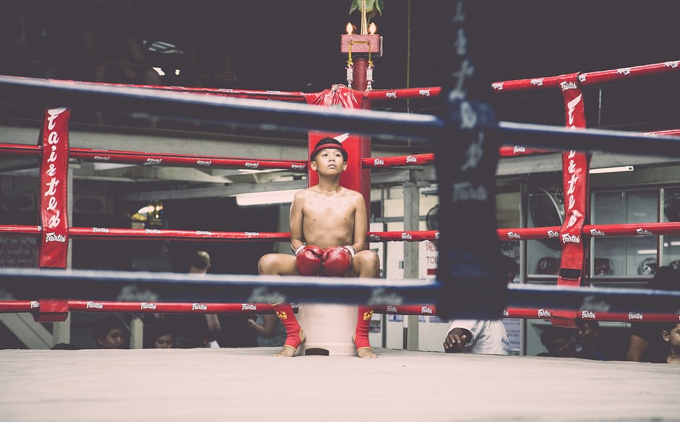 Junger Boxer sitzt in einer Ecke im Ring.