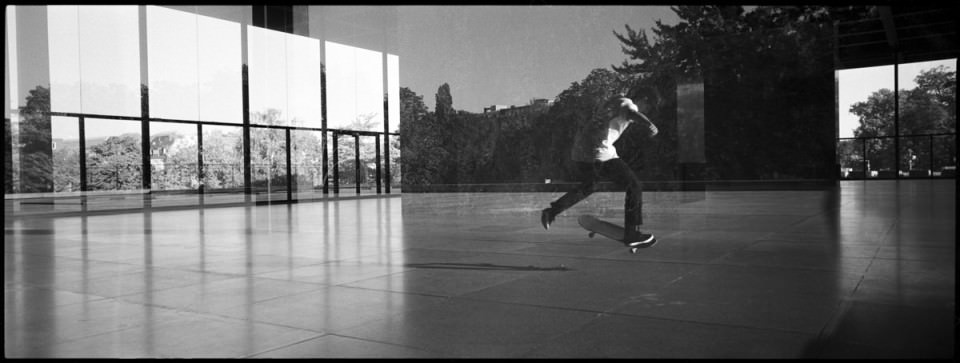 Skater mit Spiegelung einer Fensterfront.