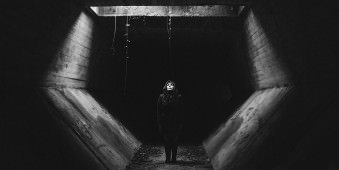 Eine Frau in einem Tunnel unter einem Lichtschacht.